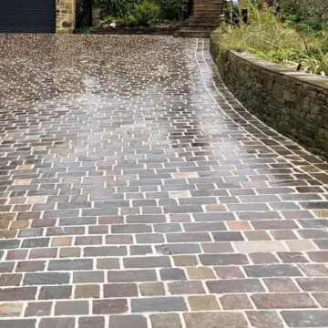 A brick driveway with a garage door