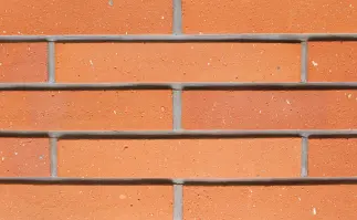 Gray wall with a small hole, up close, featuring of stone pattern.