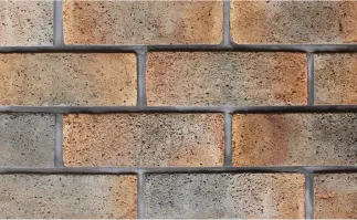 Gray wall with a small hole, up close, featuring of stone pattern.